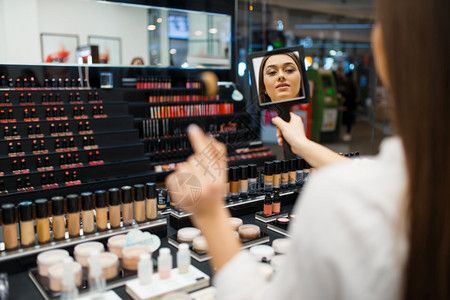 美女銷售員在化妝品店是化妝品的美女背景